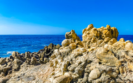Blue turquoise water and extremely beautiful huge big surfer waves rocks cliffs stones mountains and boulders on the beach in Zicatela Puerto Escondido Oaxaca Mexico.の写真素材