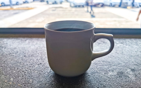 Cup of americano black coffee with spoon and plate on table food and drink in the tropical...