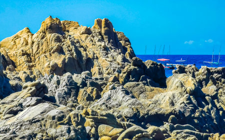 Beach sand turquoise blue water rocks cliffs boulders palm trees huge big surfer waves and panorama view on the beach Playa Manzanillo and Puerto Angelito in Puerto Escondido Oaxaca Mexico.の写真素材
