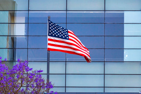 USA United States American flag in front of skyscraper made of glass in Centro Historico Mexico City Mexico.の写真素材