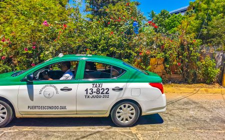 Puerto Escondido Oaxaca Mexico March 24, 2023 Colorful green turquoise blue orange yellow gold or red taxi cab car in Zicatela Puerto Escondido Oaxaca Mexico.のeditorial素材