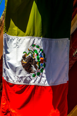 Mexican green white red flag with blue sky tourist people coast caribbean beach and palm trees in Playa del Carmen Quintana Roo Mexico.の写真素材