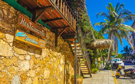 Puerto Escondido Oaxaca Mexico December 02, 2022 Typical beautiful colorful tourist street road and sidewalk with city life cars traffic buildings hotels bars restaurants and people in Zicatela Mexico.のeditorial素材