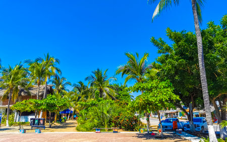 Puerto Escondido Oaxaca Mexico November 07, 2022 Typical beautiful colorful tourist street road and sidewalk with city life cars traffic buildings hotels bars restaurants and people in Zicatela Mexico.のeditorial素材