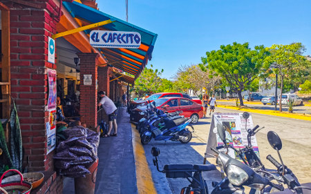 Puerto Escondido Oaxaca Mexico January 27, 2023 Typical beautiful colorful tourist street road and sidewalk with city life cars traffic buildings hotels bars restaurants and people in Zicatela Mexico.のeditorial素材