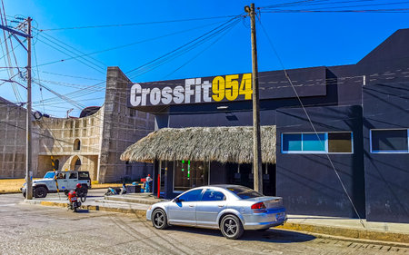 Puerto Escondido Oaxaca Mexico February 01, 2023 Typical beautiful colorful tourist street road and sidewalk with city life cars traffic buildings hotels bars restaurants and people in Zicatela Mexico.のeditorial素材