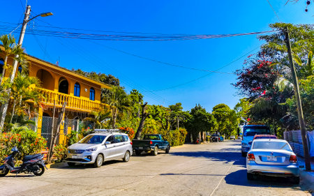 Puerto Escondido Oaxaca Mexico February 01, 2023 Typical beautiful colorful tourist street road and sidewalk with city life cars traffic buildings hotels bars restaurants and people in Zicatela Mexico.のeditorial素材
