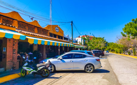 Puerto Escondido Oaxaca Mexico February 01, 2023 Typical beautiful colorful tourist street road and sidewalk with city life cars traffic buildings hotels bars restaurants and people in Zicatela Mexico.のeditorial素材