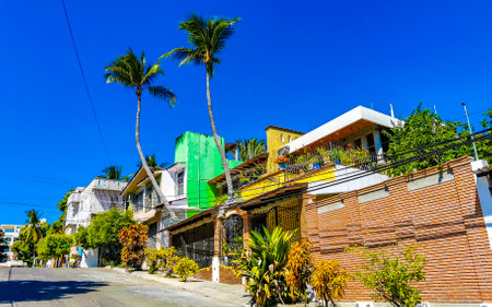 Puerto Escondido Oaxaca Mexico February 15, 2023 Typical beautiful colorful tourist street road and sidewalk with city life cars traffic buildings hotels bars restaurants and people in Zicatela Mexico.のeditorial素材