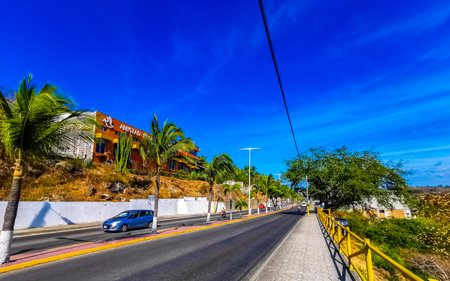 Puerto Escondido Oaxaca Mexico March 01, 2023 Typical beautiful colorful tourist street road and sidewalk with city life cars traffic buildings hotels bars restaurants and people in Zicatela Mexico.のeditorial素材