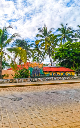 Puerto Escondido Oaxaca Mexico October 12, 2022 Typical beautiful colorful tourist street road and sidewalk with city life cars traffic buildings hotels bars restaurants and people in Zicatela Mexico.のeditorial素材
