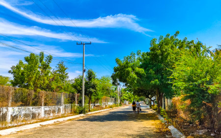 Puerto Escondido Oaxaca Mexico January 20, 2023 Typical beautiful colorful tourist street road and sidewalk with city life cars traffic buildings hotels bars restaurants and people in Zicatela Mexico.のeditorial素材