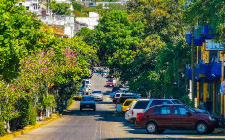 Puerto Escondido Oaxaca Mexico January 20, 2023 Typical beautiful colorful tourist street road and sidewalk with city life cars traffic buildings hotels bars restaurants and people in Zicatela Mexico.のeditorial素材
