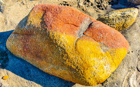 Yellow Orange Red Stone Rock On The Beach Sand in Zicatela Puerto Escondido Oaxaca Mexico.の写真素材