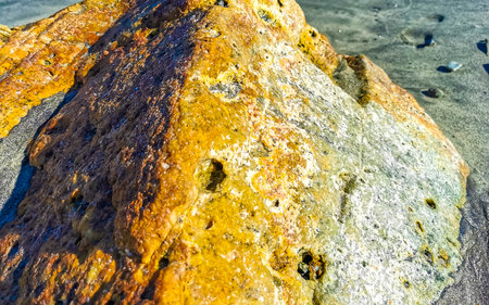 Yellow Orange Red Stone Rock On The Beach Sand in Zicatela Puerto Escondido Oaxaca Mexico.の写真素材