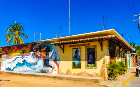 Puerto Escondido Oaxaca Mexico January 27, 2023 Typical beautiful colorful tourist street road and sidewalk with city life cars traffic buildings hotels bars restaurants and people in Zicatela Mexico.のeditorial素材