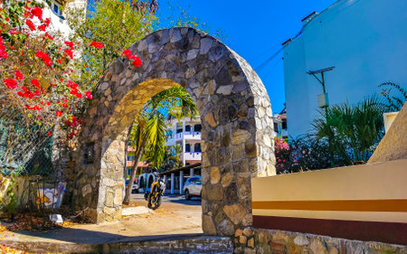 Puerto Escondido Oaxaca Mexico March 25, 2023 Typical beautiful colorful tourist street road and sidewalk with city life cars traffic buildings hotels bars restaurants and people in Zicatela Mexico.のeditorial素材