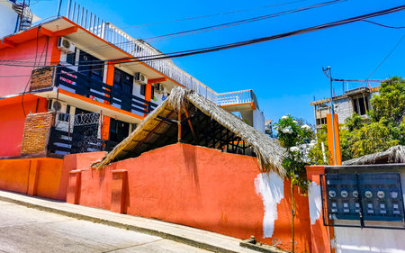 Puerto Escondido Oaxaca Mexico March 29, 2023 Typical beautiful colorful tourist street road and sidewalk with city life cars traffic buildings hotels bars restaurants and people in Zicatela Mexico.のeditorial素材