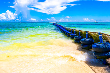 Tropical Mexican Caribbean beach and sea with Sargazo seaweed sea weed net rope and buoys in clear turquoise blue water in Playa del Carmen Mexico.の写真素材