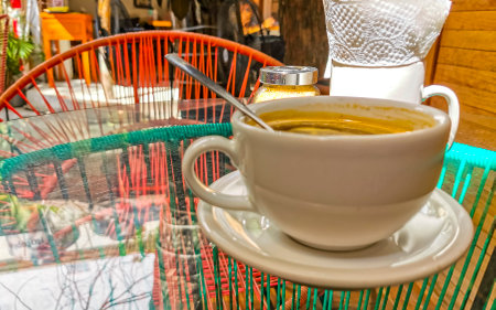 Glass cup of americano black coffee with spoon and plate on table food and drink in the restaurant cafe in Playa del Carmen Quintana Roo Mexico.の写真素材