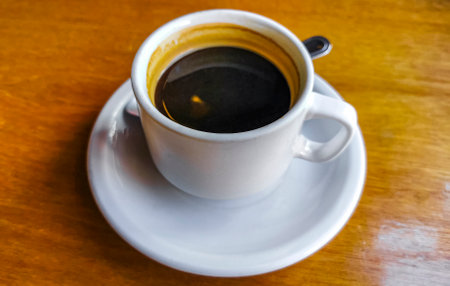 Glass cup of americano black coffee with spoon and plate on table food and drink in the restaurant cafe in Playa del Carmen Quintana Roo Mexico.の写真素材