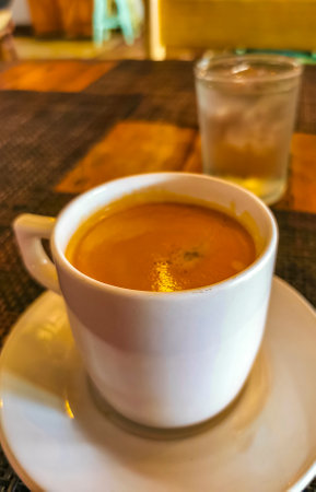 Glass cup of americano black coffee with spoon and plate on table food and drink in the restaurant cafe in Playa del Carmen Quintana Roo Mexico.の写真素材