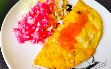 Mexican empanada with cabbage and hot sauce on white plate background from Playa del Carmen in Mexico.の写真素材