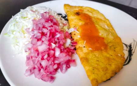 Mexican empanada with cabbage and hot sauce on white plate background from Playa del Carmen in Mexico.の写真素材