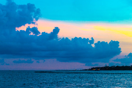 Awesome amazing and colorful sunset sunrise at the tropical Mexican Caribbean beach landscape panorama with clear turquoise blue water resorts and palm trees in Playa del Carmen Mexico.の写真素材