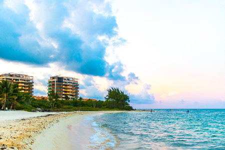 Awesome amazing and colorful sunset sunrise at the tropical Mexican Caribbean beach landscape panorama with clear turquoise blue water resorts and palm trees in Playa del Carmen Mexico.の写真素材