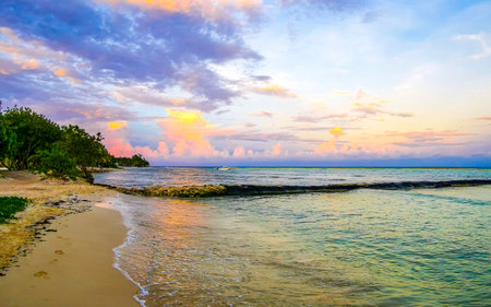 Awesome amazing and colorful sunset sunrise at the tropical Mexican Caribbean beach landscape panorama with clear turquoise blue water resorts and palm trees in Playa del Carmen Mexico.の写真素材