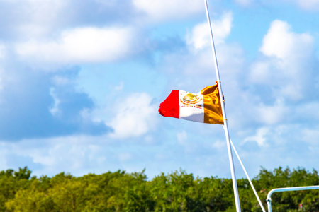 Mexican green white red flag at Puerto de ChiquilÃ¡ with blue sky and nature in Quintana Roo Mexico.の写真素材