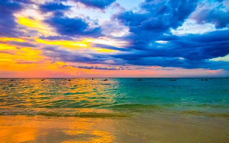 Awesome amazing and colorful sunset sunrise at the tropical Mexican Caribbean beach landscape panorama with clear turquoise blue water resorts and palm trees in Playa del Carmen Mexico.の写真素材