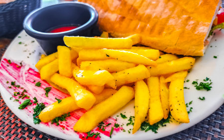 Baguette or sandwich toast bread with chicken tomato salad and potato fries in Playa del Carmen...