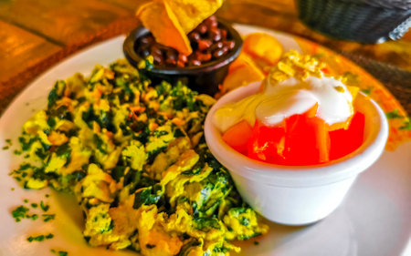 Mexican breakfast with scrambled eggs with spinach fruit and potatoes nicely arranged on white plate in Playa del Carmen Quintana Roo Mexico.の写真素材