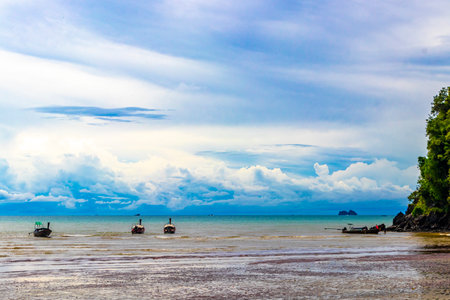 Beautiful tropical paradise panorama view on turquoise water beach with longtail boat boats and between limestone rocks on Noppharat Thara Beach in Ao Nang Krabi Thailand.の写真素材