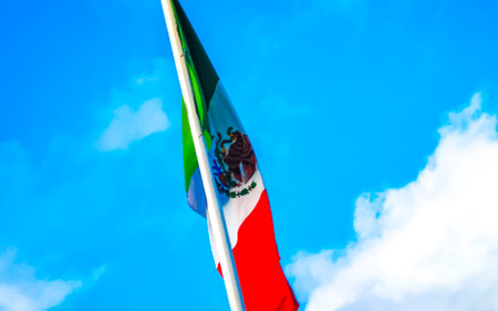 Mexican green white red flag with blue sky and clouds in Playa del Carmen Quintana Roo Mexico.の写真素材