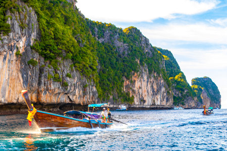 Longtail long tail boat boats at the beautiful famous beach lagoon between limestone rocks and turquoise water on Koh Phi Phi Leh island in Ao Nang Krabi Thailand.の写真素材