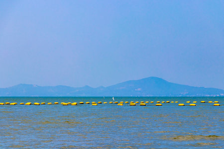 Tropical beach waves sand water sea and mountains in Jomtien Beach Pattaya Bang Lamung Chon Buri...