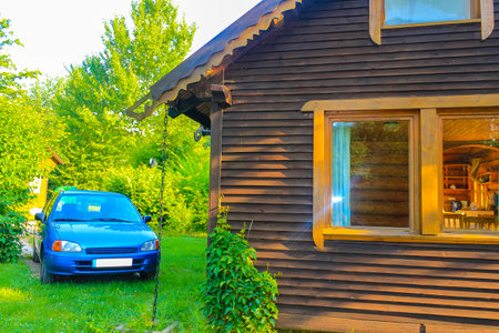 Wooden cottage cottage and parked car next to it in nature in Hemmoor Hechthausen Cuxhaven Lower Saxony Germany.の写真素材