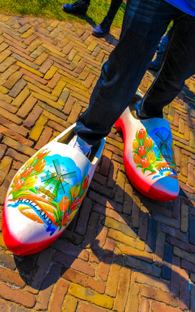 Lisse South Holland Netherlands April 4, 2014 Man tourist with large wooden Dutch clogs shoes in...