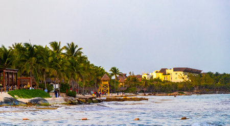 Tropical mexican caribbean beach and sea with people sun loungers parasols resort turquoise water and waves in Playa del Carmen Quintana Roo Mexico.のeditorial素材
