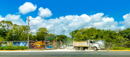 Tropical highway buildings trucks cars road palm trees in Playa del Carmen Quintana Roo Mexico.のeditorial素材