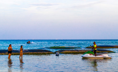 Tropical mexican caribbean beach and sea with people sun loungers parasols resort turquoise water and waves in Playa del Carmen Quintana Roo Mexico.のeditorial素材