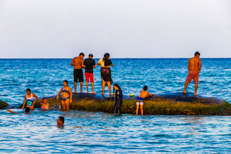 Tropical mexican caribbean beach and sea with people sun loungers parasols resort turquoise water and waves in Playa del Carmen Quintana Roo Mexico.のeditorial素材