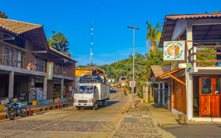 Mazunte Oaxaca Mexico November 22, 2022 Idyllic tourist street with restaurants houses people cars and hotels stores in Mazunte Oaxaca Mexico.のeditorial素材