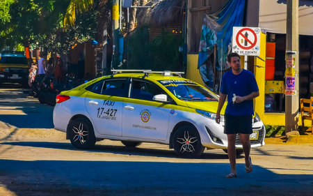 Puerto Escondido Oaxaca Mexico January 27, 2023 Colorful green turquoise blue orange yellow gold or red taxi cab car in Zicatela Puerto Escondido Oaxaca Mexico.のeditorial素材