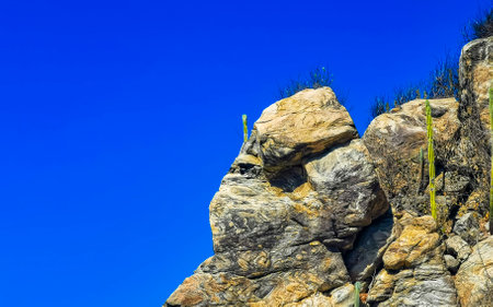 Beautiful rocks cliffs stones and boulders on mountain with natural stairs on the beach in Zicatela Puerto Escondido Oaxaca Mexico.の写真素材