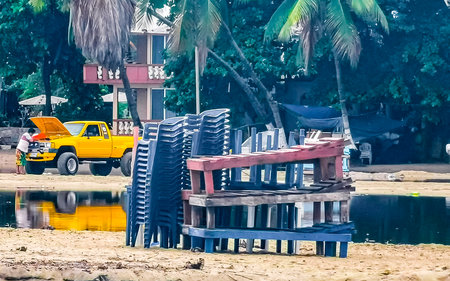Puerto Escondido Oaxaca Mexico October 18, 2022 Parasols umbrellas sun loungers palms people rocks and waves at the tropical Mexican beach in Zicatela Puerto Escondido Oaxaca Mexico.のeditorial素材