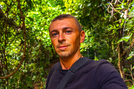 Handsome male tourist man at tropical jungle and forest hiking trails through nature to the mountain peak in Chiang Mai Amphoe Mueang Chiang Mai Thailand in Southeastasia Asia.の写真素材